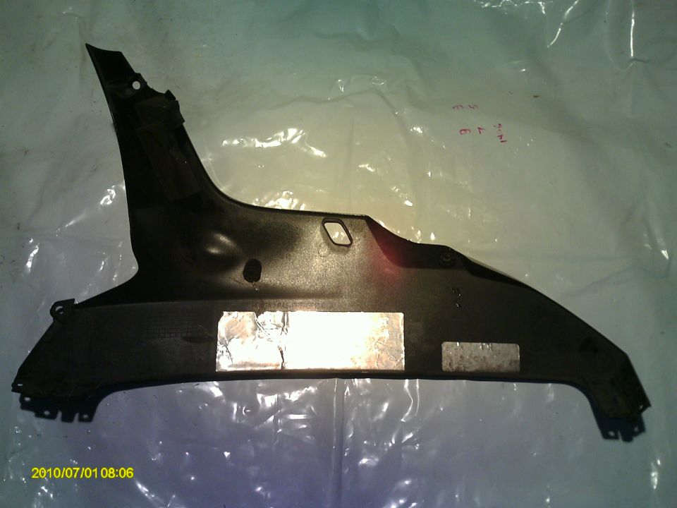 Black plastic body panel with silver tape on it