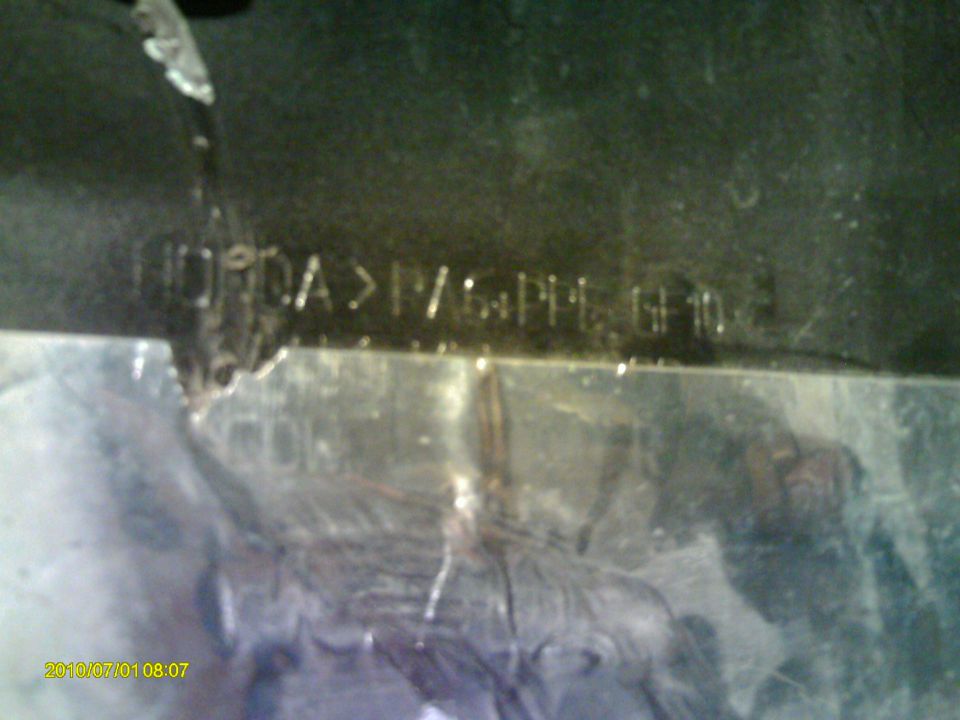 Stamped metal plate with text 'HONDA>PV/PPPE GF10'