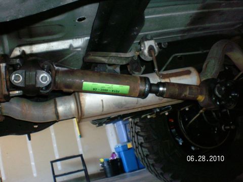 1996 Ford Bronco - Undercarriage view of a vehicle's driveshaft and exhaust system, with a visible part number sticker.