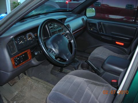 1984 Ford Bronco - Interior view of a green Jeep Grand Cherokee, showing the dashboard, steering wheel, and seats. A date stamp indicates the photo was taken…