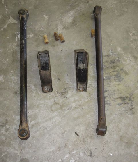 1988 Ford Bronco - Vehicle suspension parts laid out on a concrete surface, likely for replacement or repair.