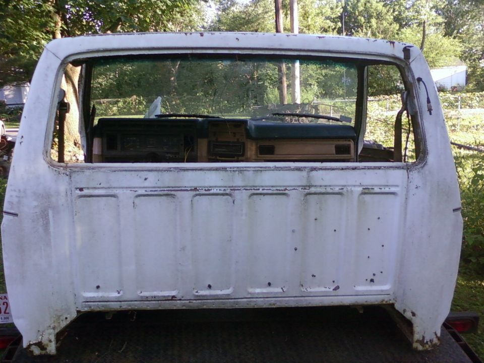 White pickup truck cab rear view, showing dashboard and bed panels. Likely 1980s model