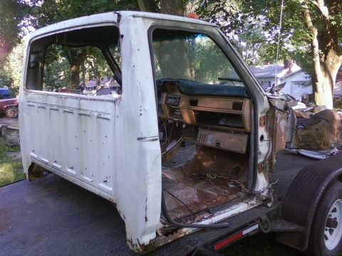 1989 Ford Bronco - Cab of a pickup truck, likely from the 1980s, is shown on a trailer with its interior exposed.
