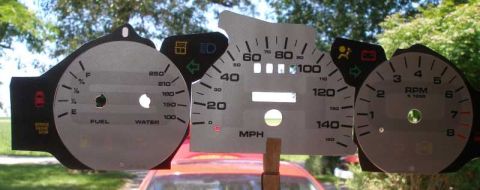 1997 Ford Taurus - Custom gauge cluster parts are displayed in front of a red car's windshield.