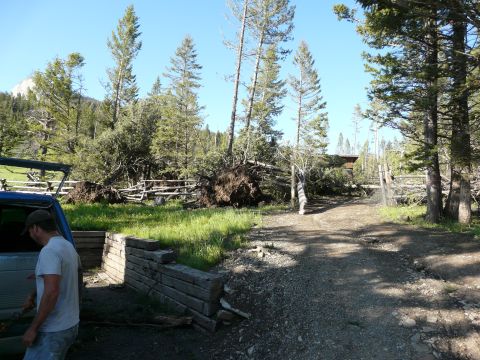 2006 Ford E350 - A blue van door is visible in the foreground, with a man standing nearby, amidst a landscape showing significant tornado damage including u…