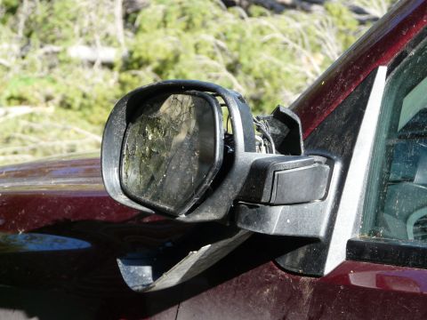 2006 Ford E350 - The side mirror assembly is broken, with cracked glass and exposed wiring.