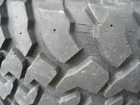 1990 Toyota Pickup/SR5 - The tire tread shows significant cracking and wear, with small holes visible in the rubber.