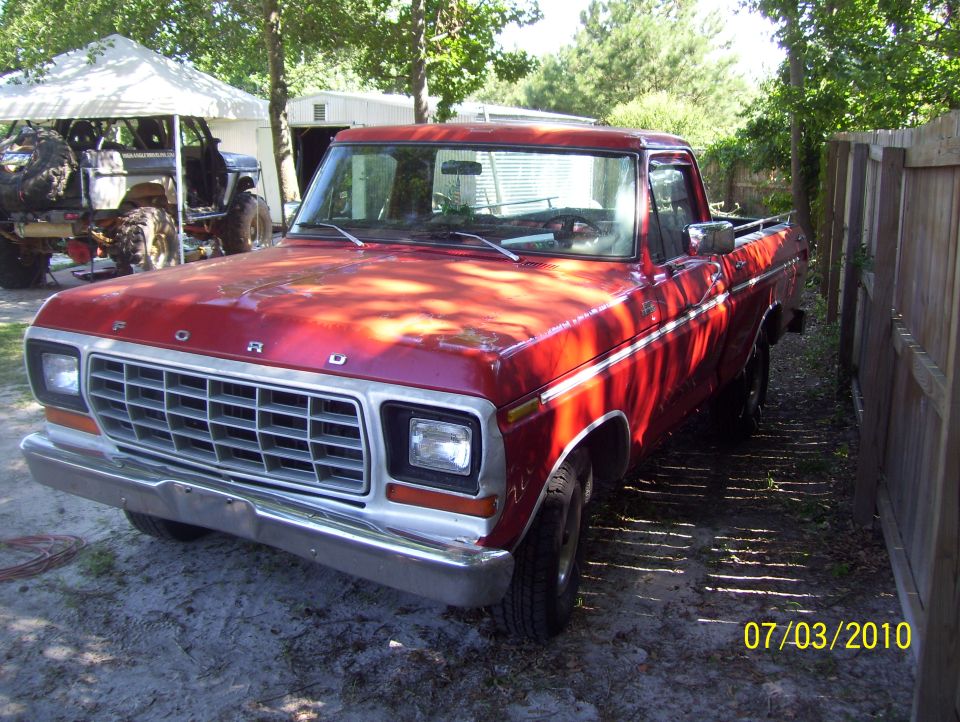 Red Ford pickup truck with chrome grille and bumper, parked outdoors