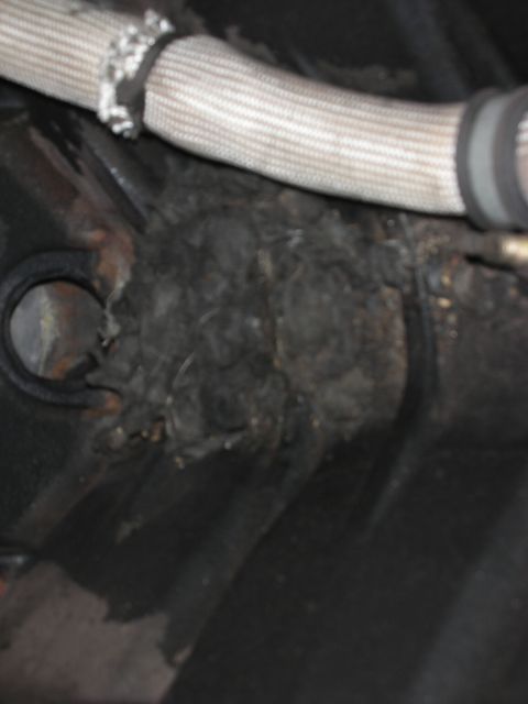 1992 Ford Crown Victoria - Accumulated debris and damaged hose insulation are visible in this engine bay close-up.