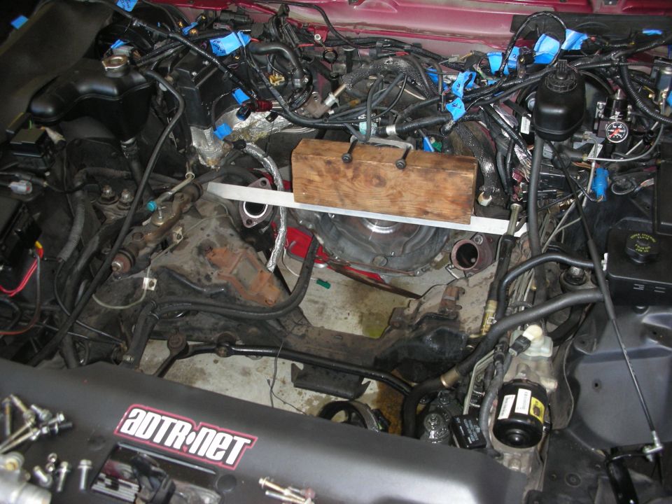 Engine bay with transmission removed, showing engine block and wiring