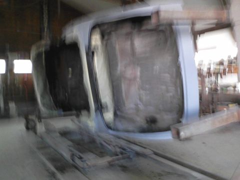 1960 Ford Falcon - The underside of a car body is visible as it is suspended on a lift in a workshop.