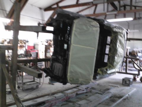 1960 Ford Falcon - Car body undergoing work in a workshop, suspended upside down.