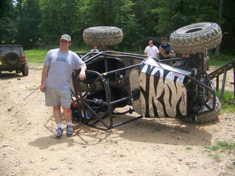 1992 Jeep YJ - An off-road buggy lies on its side, with a man and other vehicles nearby.