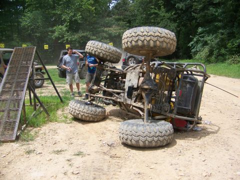 1992 Jeep YJ - An off-road vehicle has flipped onto its side during an event, with spectators observing the scene.