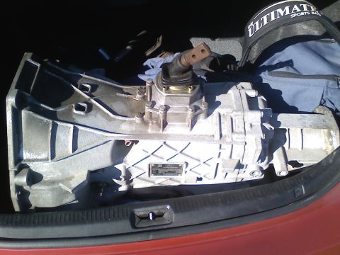 1990 Ford Bronco - A transmission is visible in the trunk of a car, possibly for a diesel swap project.