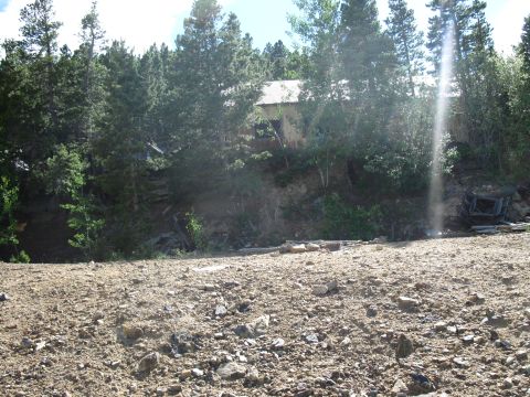 1978 Ford F-150 - An old building sits on a wooded slope above a rocky, barren area.