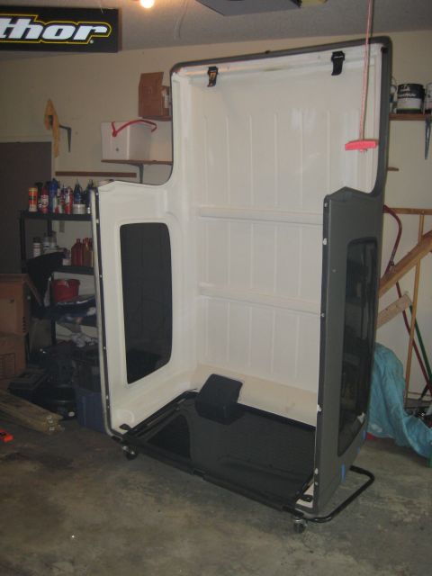 2005 Jeep Wrangler - A white Jeep Wrangler hard top is stored on a stand in a garage.