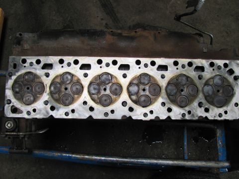 2005 Dodge 3500 - A close-up view of a disassembled engine cylinder head, showing multiple valves within their respective chambers.