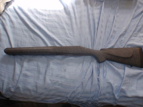 1991 Ford Bronco - A close-up view of a rifle stock, resting on a wrinkled blue fabric surface.