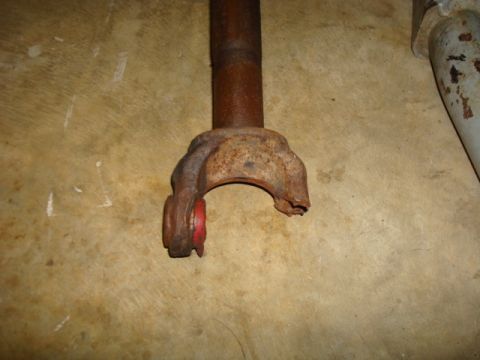 1995 Ford Bronco - A close-up view of a rusty driveshaft yoke with a red bushing.