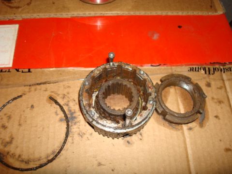 1995 Ford Bronco - A disassembled and rusty hub assembly, showing the splined center and a separate locking ring, lies on a cardboard surface.