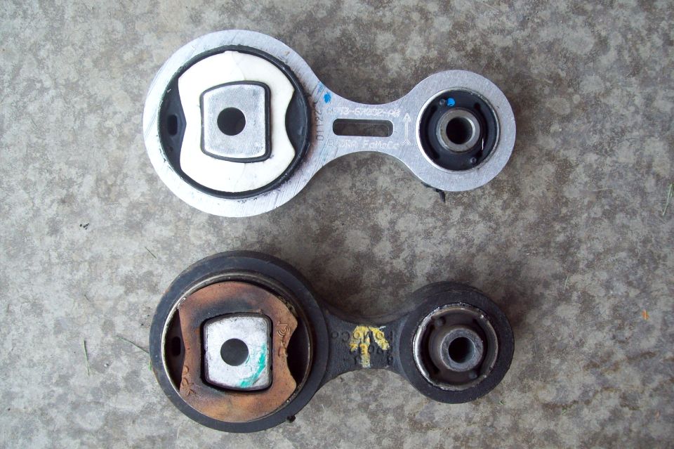 New and old dogbone torque engine mounts on concrete, new one marked FoMoCo