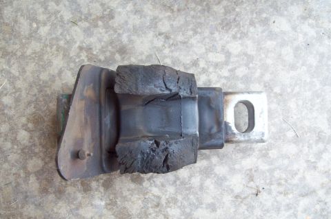 2006 Ford Fusion - A worn engine/transmission mount showing a metal bracket with an oval mounting hole and severely cracked, deteriorated rubber that has crum…
