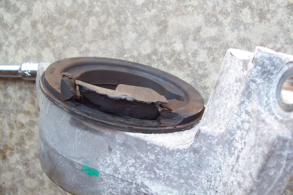 Grease-filled metal mount in a vise being cleaned out during service