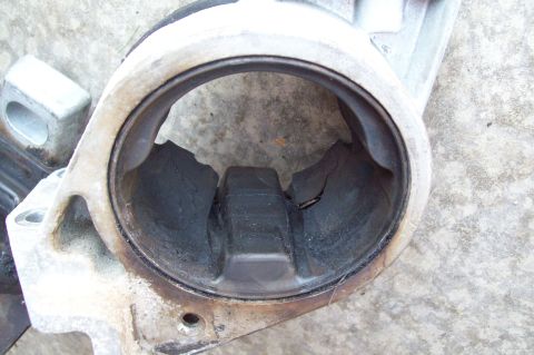 2006 Ford Fusion - Close-up of a heavily carbon-fouled cast aluminum engine component, likely a cylinder or throttle/intake bore, showing thick black soot dep…