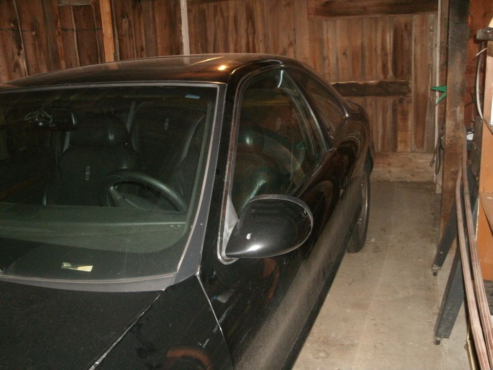 black 1998 Lincoln Mark VIII parked inside a wooden garage