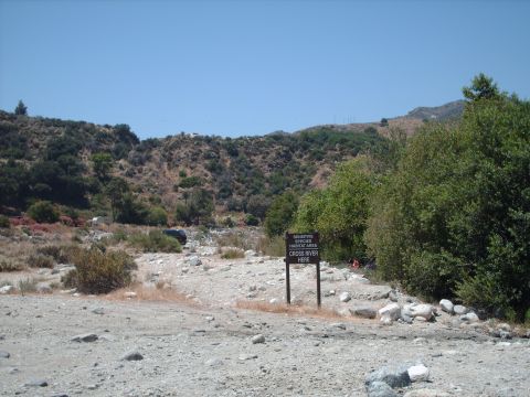 1986 Ford Bronco - A dark SUV is parked in a dry riverbed, near a sign indicating a sensitive species habitat area.