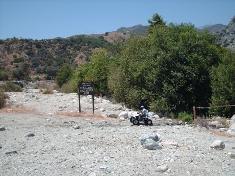 1986 Ford Bronco - ATV rider in a natural landscape with a sign indicating a sensitive species habitat area.