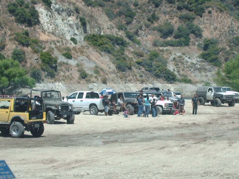 1986 Ford Bronco - A group of off-road vehicles are parked together in a scenic, natural area.