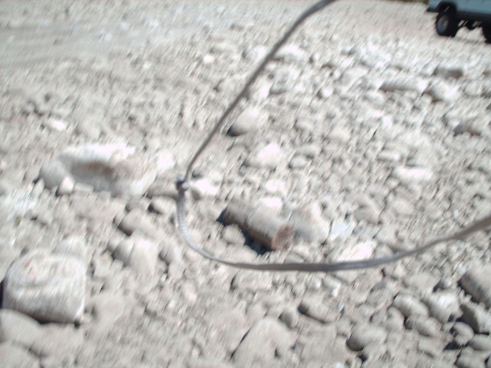 Gravel ground with a dark cable running across it