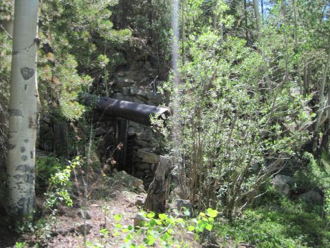 1978 Ford F-150 - Abandoned mine shaft entrance with a large pipe overhead, set in a wooded area.
