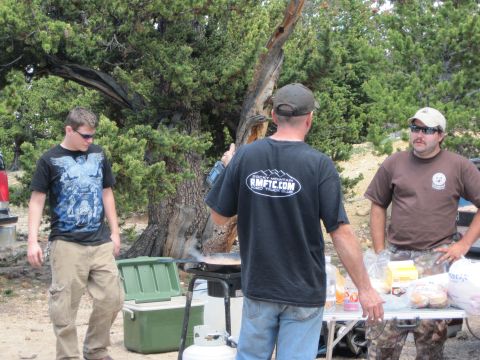 1978 Ford F-150 - Three men are seen at a campsite, with one man cooking on a portable grill.