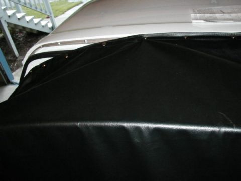 1995 Ford Bronco - Installing a black vinyl soft top onto a vehicle, showing the attachment points.
