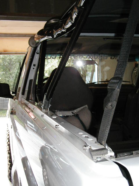 1995 Ford Bronco - Interior view of a Ford Bronco, focusing on the soft top installation hardware and black seats.