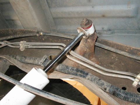 1995 Ford Bronco - Close-up view of the rear shock absorber and associated brake lines, showing the mounting hardware and suspension components.