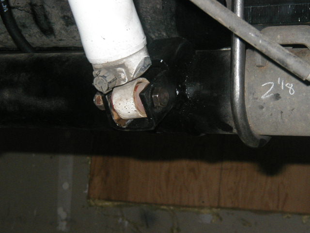 Underside view of a driveshaft U-joint at a rear axle yoke, marked 2 1/8