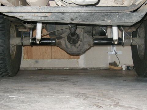 1995 Ford Bronco - Underside view of a vehicle's rear axle, leaf springs, and shock absorbers.