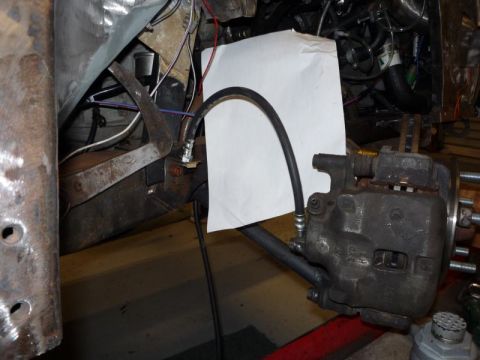 1969 MINI Cooper - Brake caliper and hose assembly, likely from a car's front suspension system.
