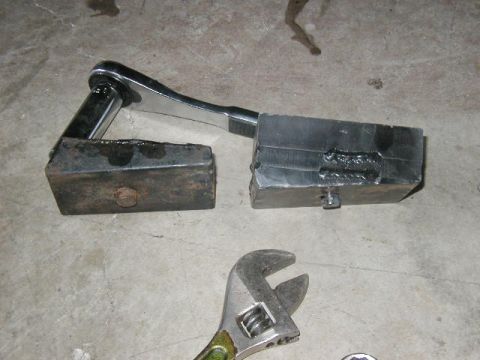 1995 Ford Bronco - Custom metal blocks, likely for a vehicle modification, are shown with tools on a concrete surface.