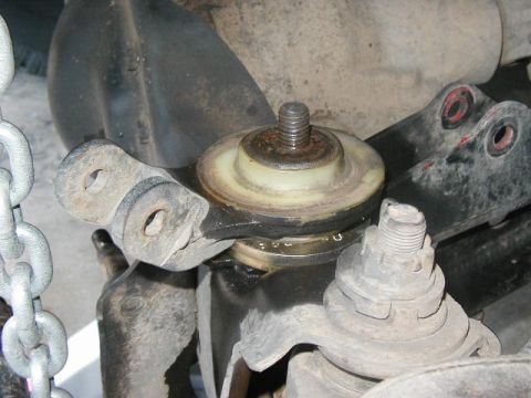 1995 Ford Bronco - Close-up view of vehicle suspension components, including a ball joint and mounting bracket.
