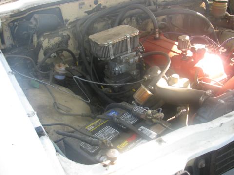 1985 Ford Bronco - Close-up of an engine bay with a carburetor and air filter assembly visible.