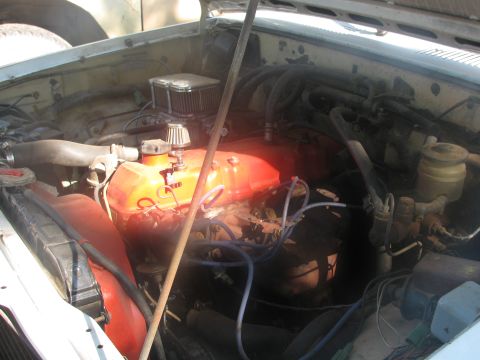 1985 Ford Bronco - The engine bay of a vehicle is shown with various components and hoses visible.