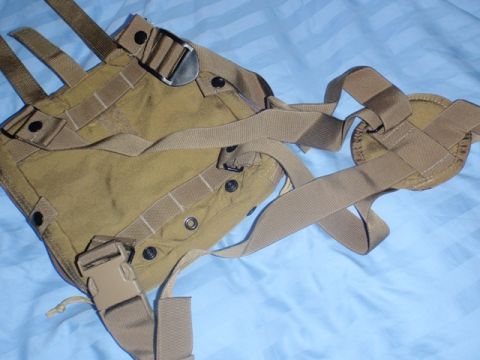 1991 Ford Bronco - A tan tactical vest with multiple straps and buckles is shown from a close-up perspective.