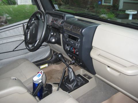 2005 Jeep Wrangler - The interior of a 2005 Jeep Wrangler is visible, including the dashboard and steering wheel.