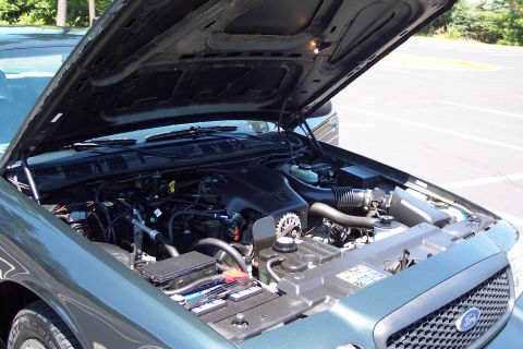 2001 Ford Crown Victoria - The engine compartment of a 2001 Ford Crown Victoria is open, revealing the motor and associated components.