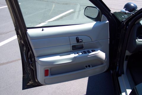 2001 Ford Crown Victoria - The interior door panel of a vehicle is visible with the door ajar.